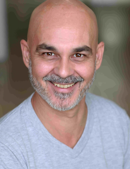 Portrait d’Olivier, comédien et animateur événementiel, souriant face caméra, spécialisé en murder party et faux serveur.